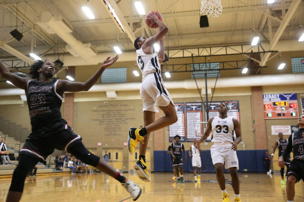 Democracy Prep's Chancelor Johnson (3) goes up for a shot against Cimarron-Memorial's JaiTwan Golden (23) in their basketball game at Legacy High School in North Las Vegas, Friday, Nov. 30, 2018. ...