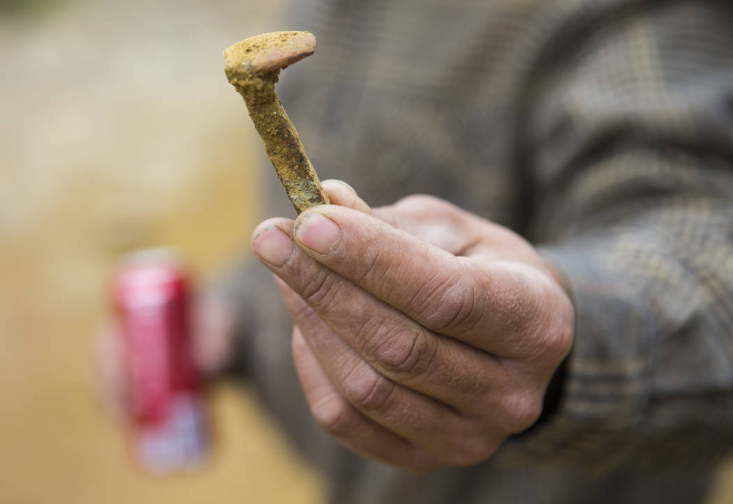 Caden Gould of Genoa holds up a mine cart nail found near an old mine while searching for vintage denim and other antiquities in south Douglas County on Thursday, Oct. 11, 2018. Mines in the area ...