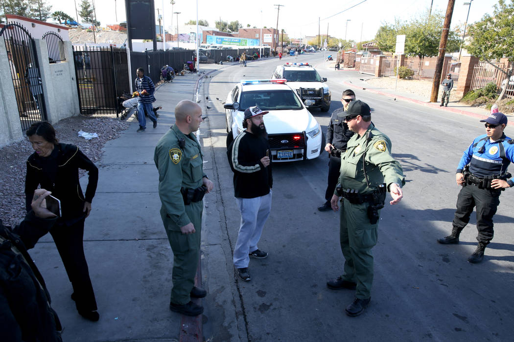 Las Vegas police argue with Joey Lankowski, center, where he was distributing food on Foremaster Lane near Las Vegas Boulevard Wednesday, Nov. 28, 2018. Lankowski was cited for parking in a red zo ...