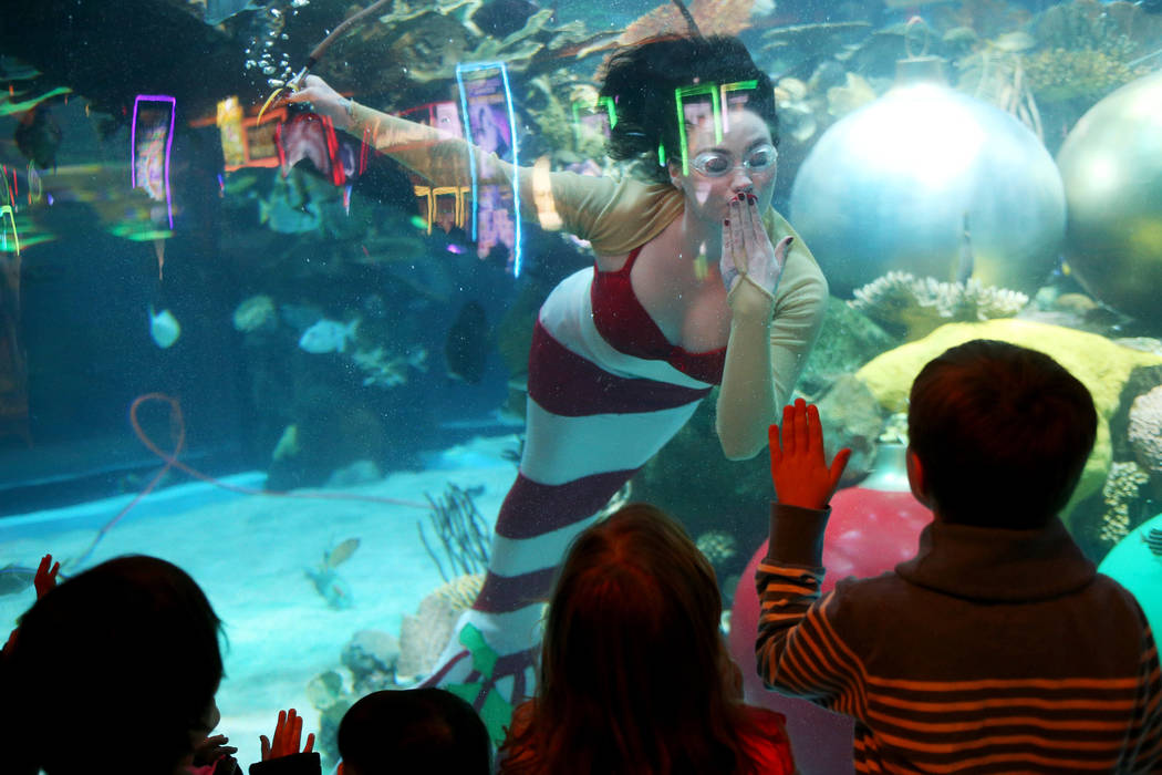 The Christmas mermaid blows a kiss to Matvay Sokolov, 6, at Silverton hotel and casino in Las Vegas, Sunday, Dec. 2, 2018. She and Santa are in the aquarium every Saturday and Sunday in December f ...