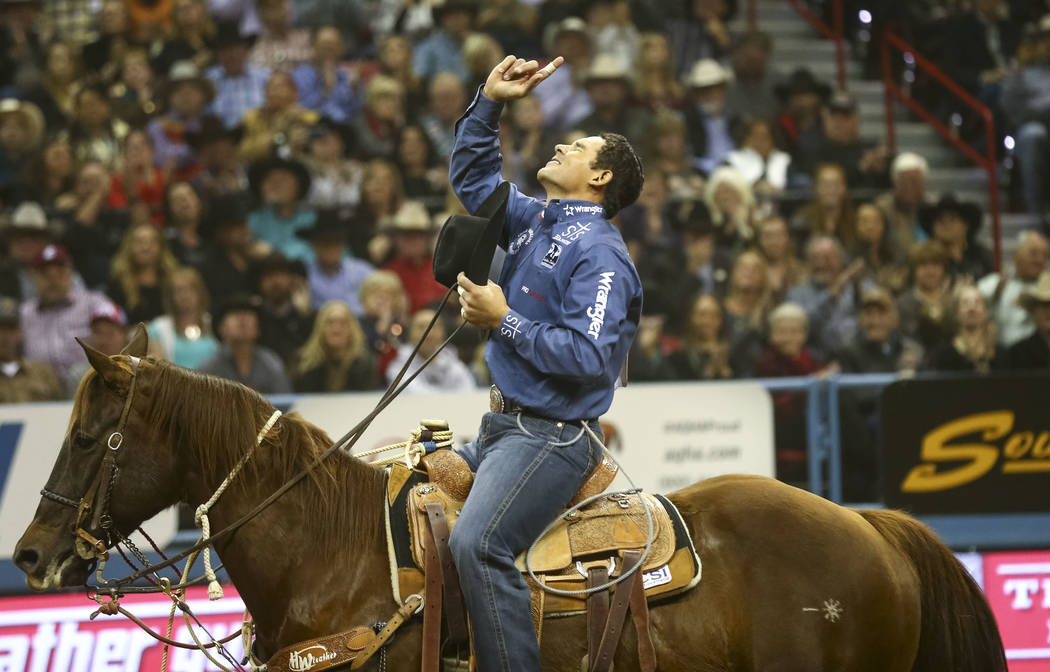 Marcos Costa of Childress, Texas points to the shy after taking part in the tie-down roping competition in the tenth go-round of the National Finals Rodeo, Saturday, Dec. 16, 2017, at the Thomas & ...