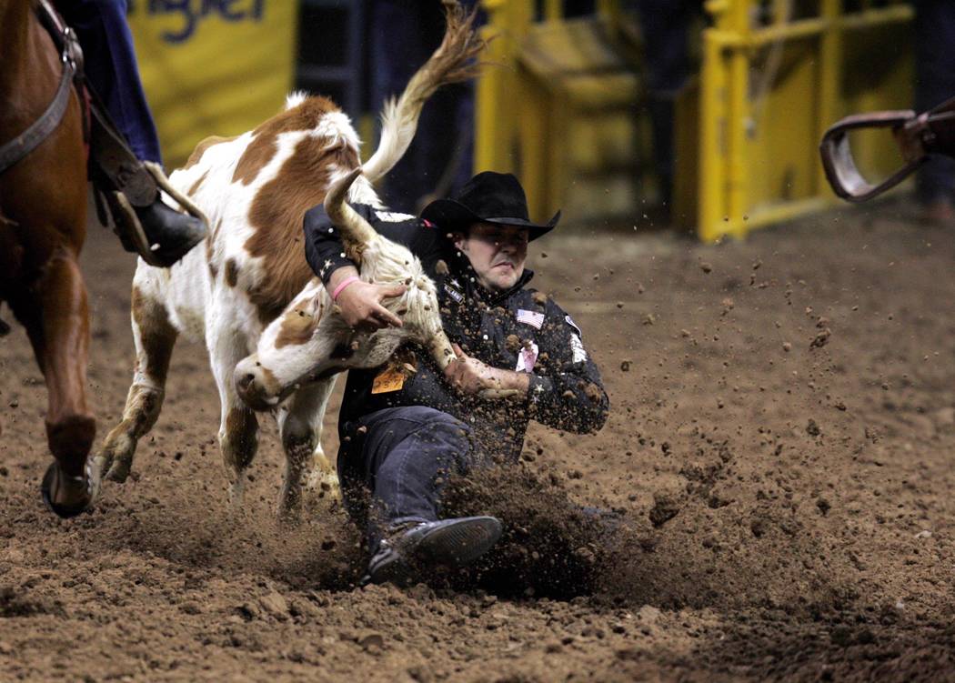 Luke Branquinho of Los Alamos, Calif., wrestles a steer in a time of 3.3 seconds to win the fifth go-around of the National Finals Rodeo at the Thomas & Mack Center Tuesday, Dec. 7, 2004. (K.M. Ca ...