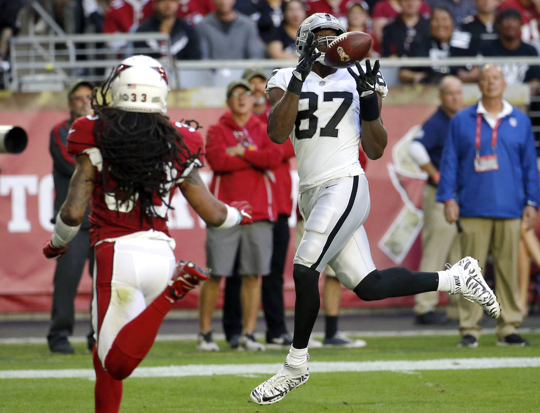 Oakland Raiders tight end Jared Cook (87) pulls in a touchdown catch as Arizona Cardinals defensive back Tre Boston (33) defends during the first half of an NFL football game, Sunday, Nov. 18, 201 ...