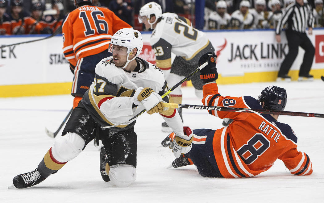 Vegas Golden Knights' Shea Theodore (27) and Edmonton Oilers' Ty Rattie (8) collide during the third period of an NHL hockey game Saturday, Dec. 1, 2018, in Edmonton, Alberta. (Jason Franson/The C ...