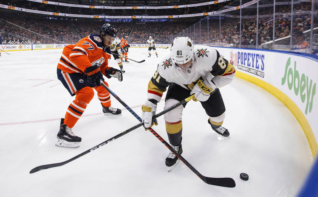 Vegas Golden Knights' Jonathan Marchessault (81) and Edmonton Oilers' Oscar Klefbom (77) compete for the puck during the first period of an NHL hockey game Saturday, Dec. 10, 2018, in Edmonton, Al ...
