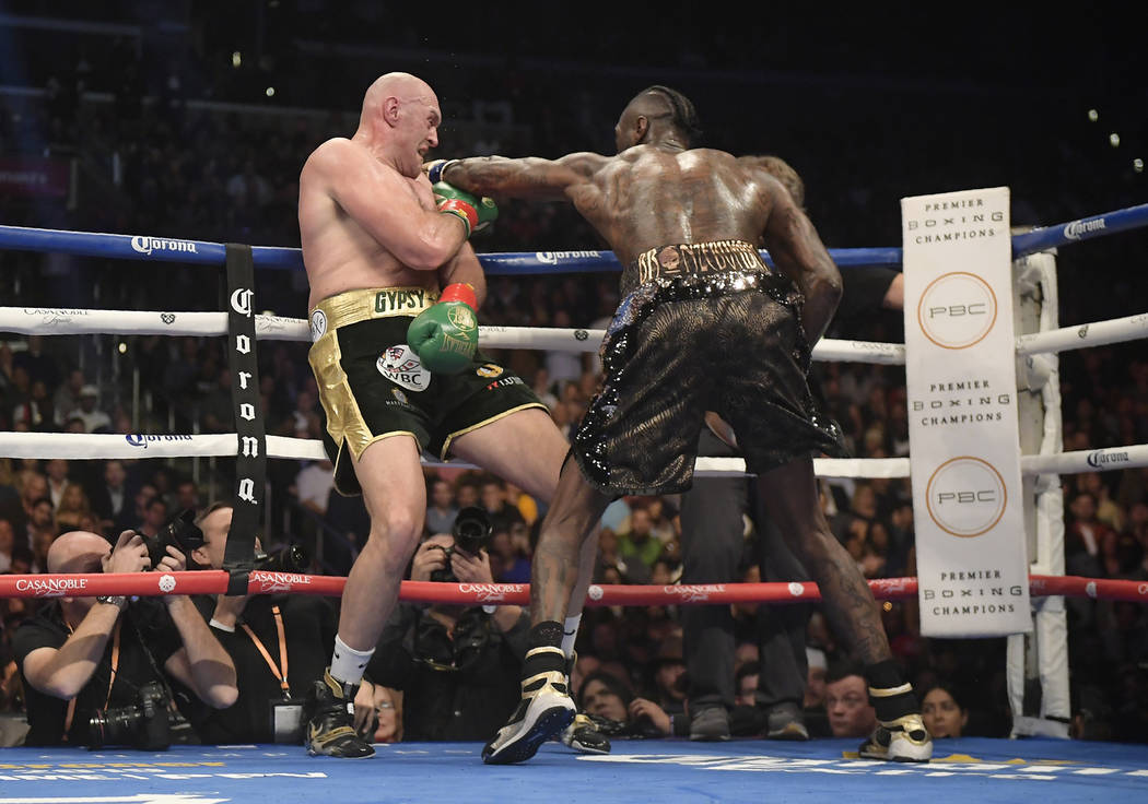 Deontay Wilder, right, connects with Tyson Fury, of England, during a WBC heavyweight championship boxing match, Saturday, Dec. 1, 2018, in Los Angeles. (AP Photo/Mark J. Terrill)