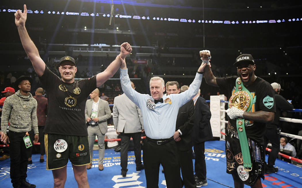 Tyson Fury, left, of England, poses with Deontay Wilder, right, along with referee Jack Reiss after their WBC heavyweight championship boxing match ended in a draw, Saturday, Dec. 1, 2018, in Los ...