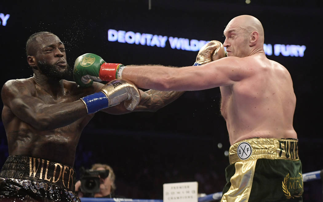 Deontay Wilder, left, and Tyson Fury, of England, trade punches during a WBC heavyweight championship boxing match, Saturday, Dec. 1, 2018, in Los Angeles. (AP Photo/Mark J. Terrill)
