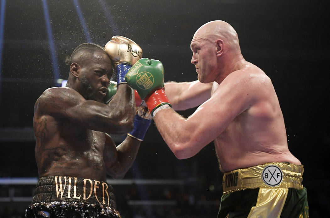 Tyson Fury, right, of England, connects with Deontay Wilder during a WBC heavyweight championship boxing match, Saturday, Dec. 1, 2018, in Los Angeles. (AP Photo/Mark J. Terrill)