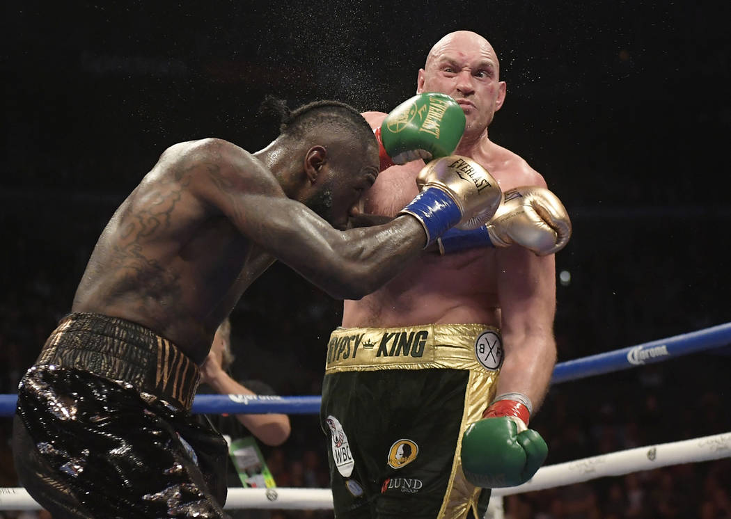 Deontay Wilder, left, connects with Tyson Fury, of England, during a WBC heavyweight championship boxing match Saturday, Dec. 1, 2018, in Los Angeles. (AP Photo/Mark J. Terrill)