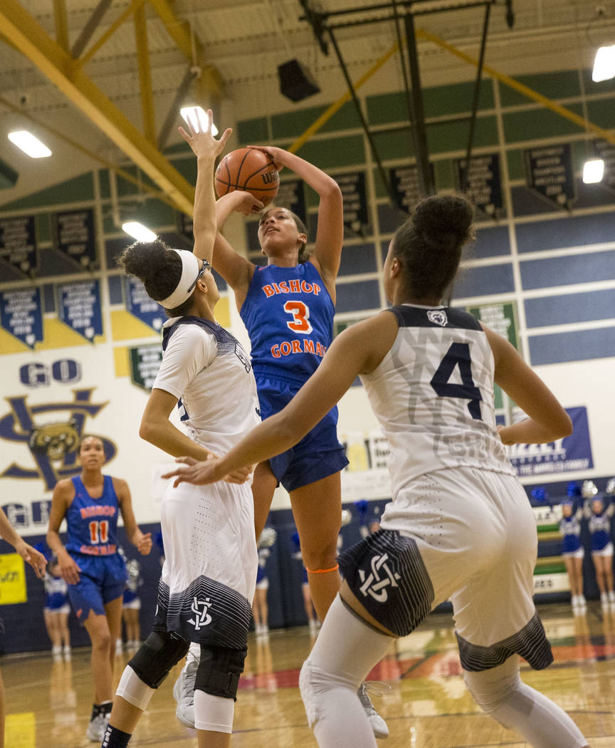 Bishop Gorman's Georgia Ohiaeri (3) shoots over Spring Valley defenders Mackenzie Carcelli, left, and Kiana Turenne (4) during the first half of a varsity basketball game at Spring Valley High Sch ...
