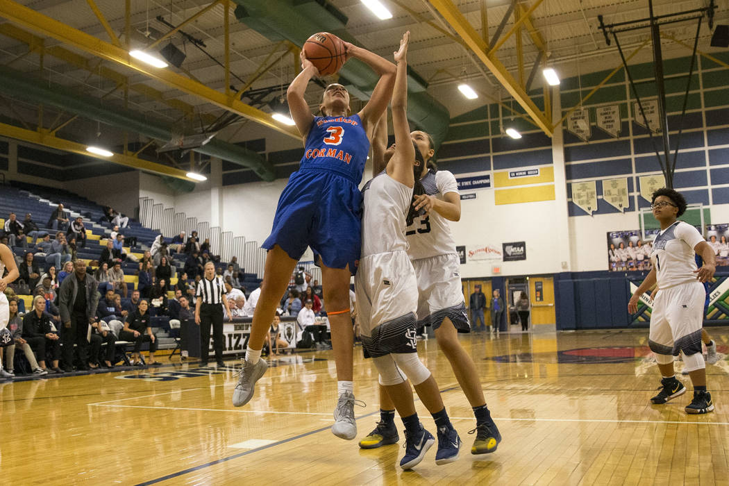Bishop Gorman's Georgia Ohiaeri (3) shoots over Spring Valley's Chelsea Camara (5) as Spring Valley's Alexus Quaadman (23) defends during the second half of a varsity basketball game at Spring Val ...