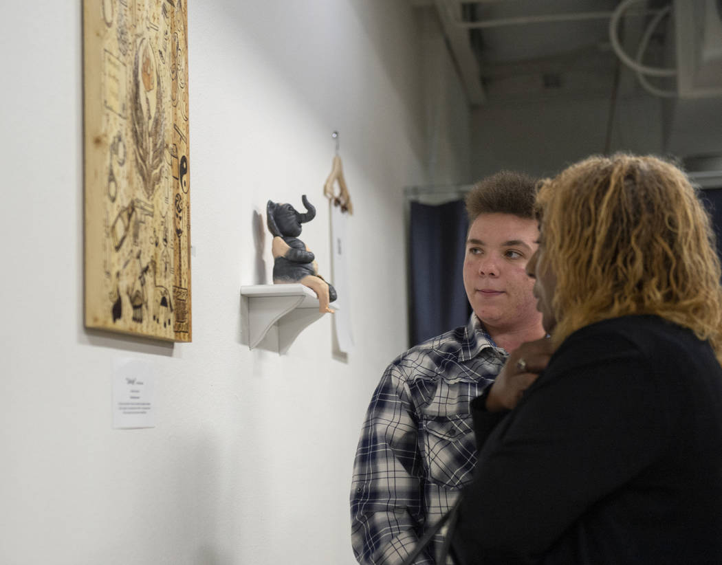 Artist Elijah Brown talks with his teacher LaToria Kern about his piece "Salvaje" on display at Core Contemporary Gallery in Las Vegas, Thursday, Dec. 6, 2018. Caroline Brehman/Las Vegas ...