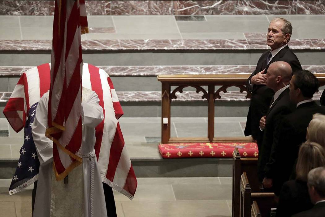 Former President George W. Bush places a hand on his chest during a funeral for former President George H.W. Bush at St. Martin's Episcopal Church Thursday, Dec. 6, 2018, in Houston. (AP Photo/Mar ...