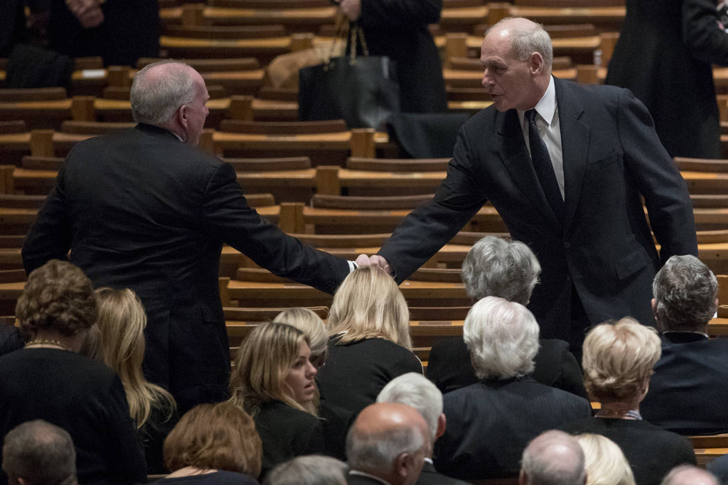Former CIA Director John Brennan, left, shakes hands with President Donald Trump's Chief of Staff John Kelly, right, before a State Funeral for former President George H.W. Bush at the National Ca ...
