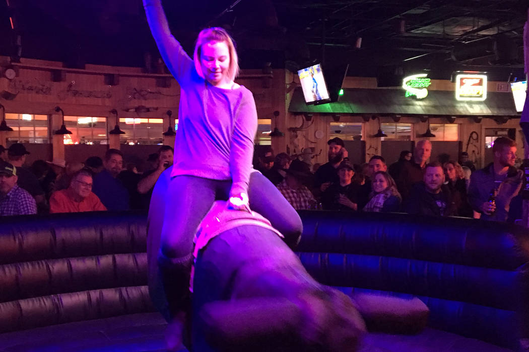 Heather Kizor of Kasota, Minn., takes a ride on the mechanical bull during Friday's Wrangler NFR viewing party at Gilley's Dance Hall & Saloon inside Treasure Island. Patrick Everson/Review-Journal