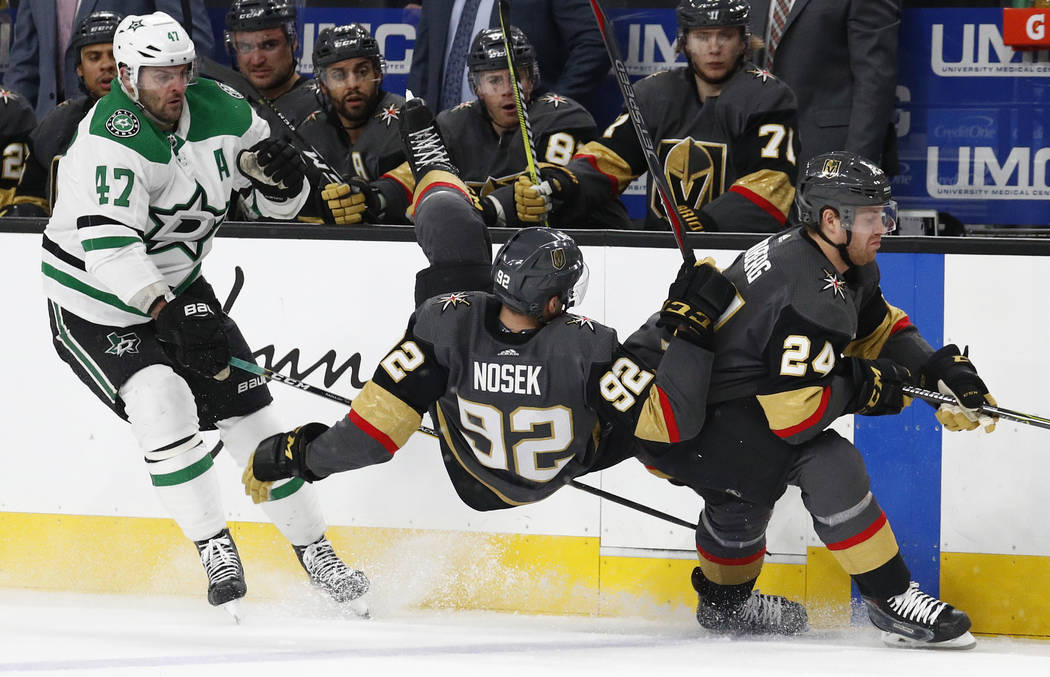 Vegas Golden Knights left wing Tomas Nosek (92) falls to the ice between Dallas Stars right wing Alexander Radulov (47) and center Oscar Lindberg during the second period of an NHL hockey game Sun ...