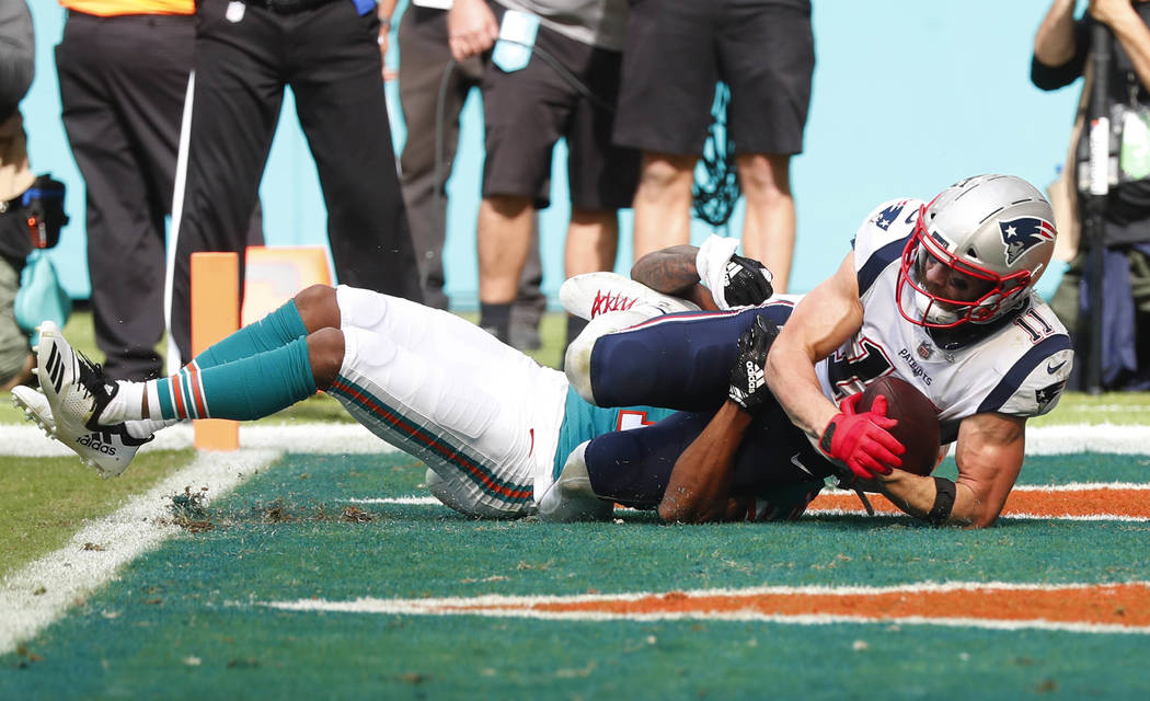 New England Patriots wide receiver Julian Edelman (11) catches a touchdown pass, during the first half of an NFL football game against the Miami Dolphins, Sunday, Dec. 9, 2018, in Miami Gardens, F ...