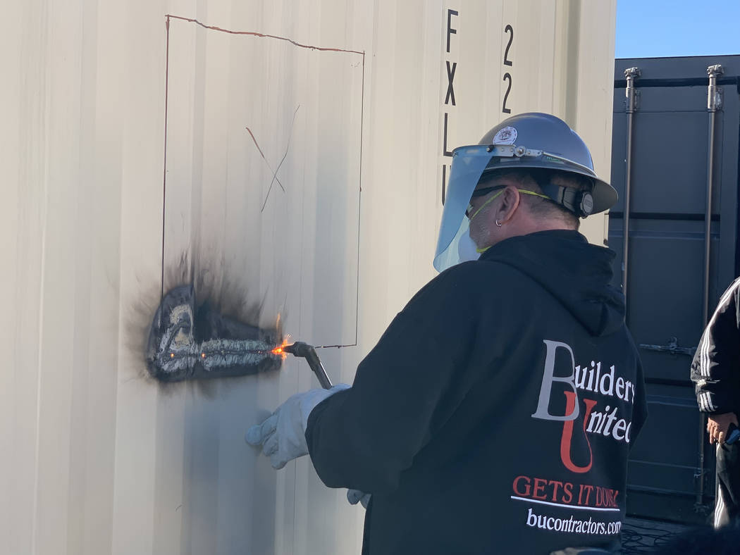 Symbolizing a ribbon cutting, Rick Rainy of Builders United uses a welding torch to start the first cut on a new container home at Veterans Village II, 50 N. 21st Street in Las Vegas on Tuesday, D ...