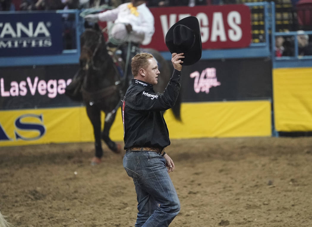 Curtis Cassidy of Alberta, Canada waives to the crowd after competing in the steer wrestling event during the sixth go-round of the National Finals Rodeo at the Thomas & Mack Center in Las Veg ...