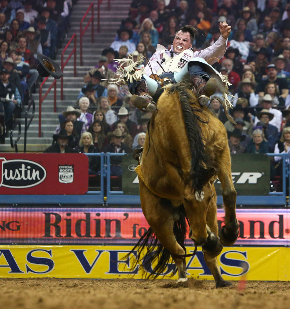 Richmond Champion of The Woodlands, Texas (24) rides "Imperial Beach" while competing in Bareback Riding during the sixth go-round of the National Finals Rodeo at the Thomas & Mack C ...