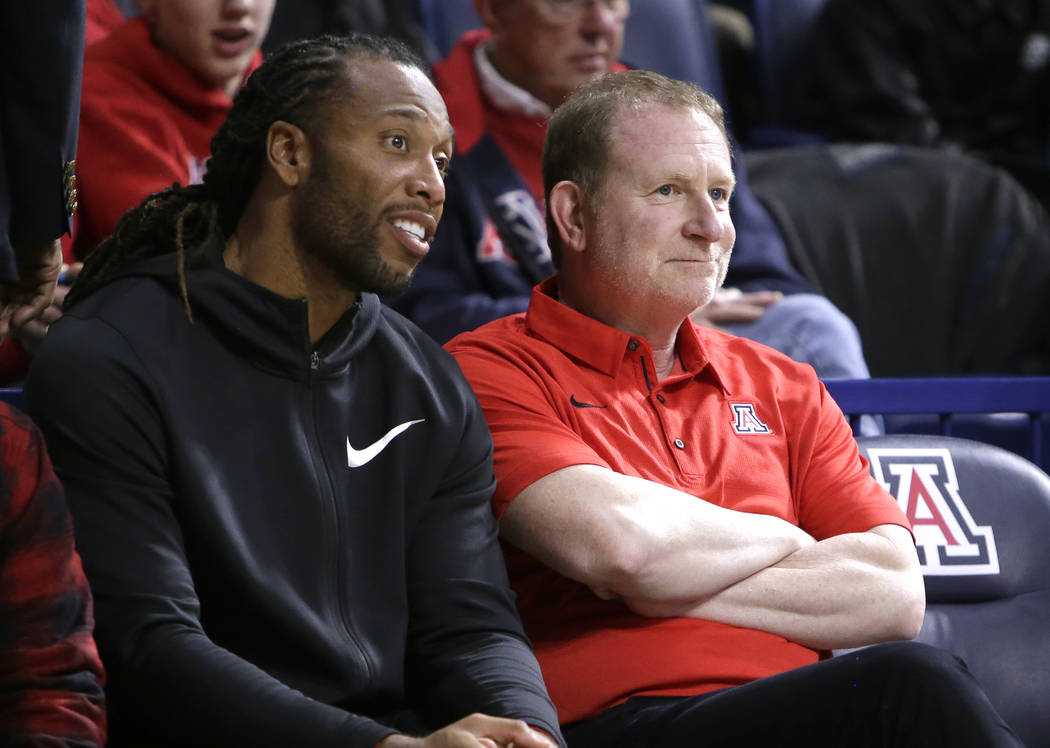Arizona Cardinals player Larry Fitzgerald and Phoenix Suns owner Robert Sarver watch an NCAA college basketball game between Arizona and Connecticut on Thursday, Dec. 21, 2017, in Tucson, Ariz. Ar ...