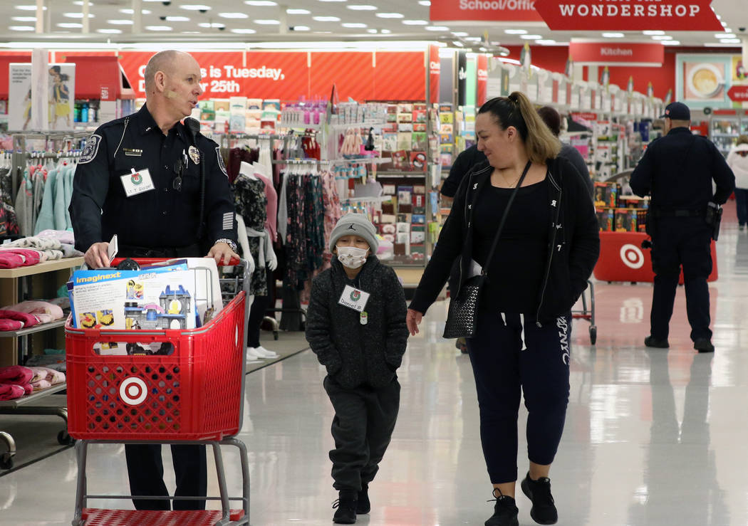 Daniel Borrayo, 6, and and his mother Ariana Ortega shop with North Las Vegas police Lt. Tom Glaizer, left, during the annual ''Shop with a Cop" event at Target at 7090 N. Fifth St. on Wednes ...