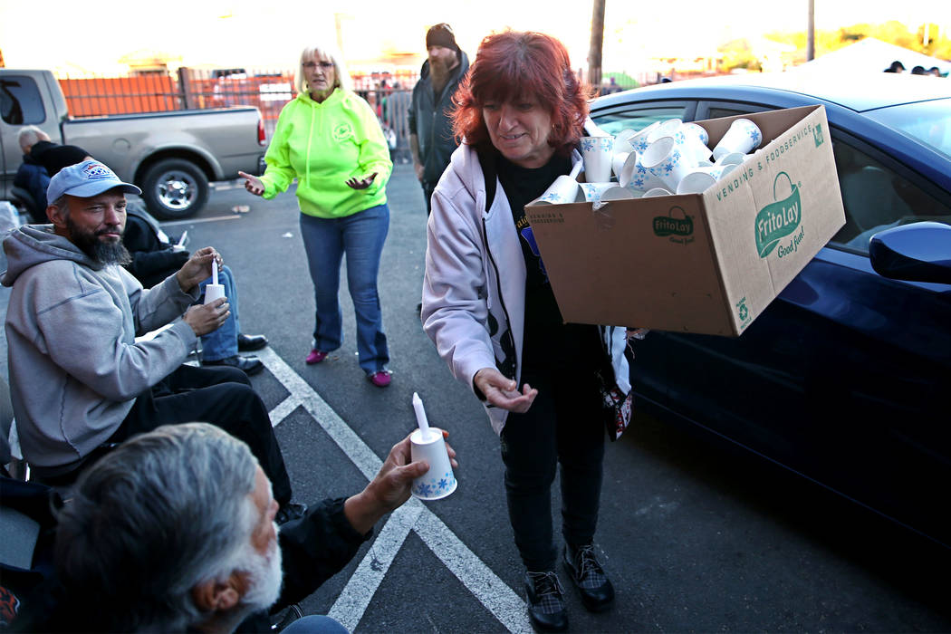 Mary Spriggs, volunteer with Straight From the Streets, hands out candles during the 23rd Annual Homeless Candlelight Vigil at the CARE Complex in Las Vegas, Thursday, Dec. 13, 2018. Erik Verduzco ...