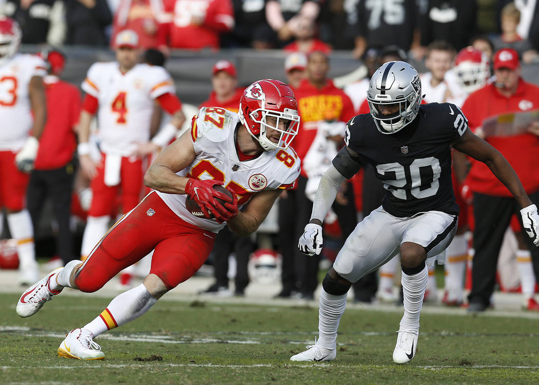 Kansas City Chiefs tight end Travis Kelce (87) runs in front of Oakland Raiders cornerback Daryl Worley (20) during the second half of an NFL football game in Oakland, Calif., Sunday, Dec. 2, 2018 ...