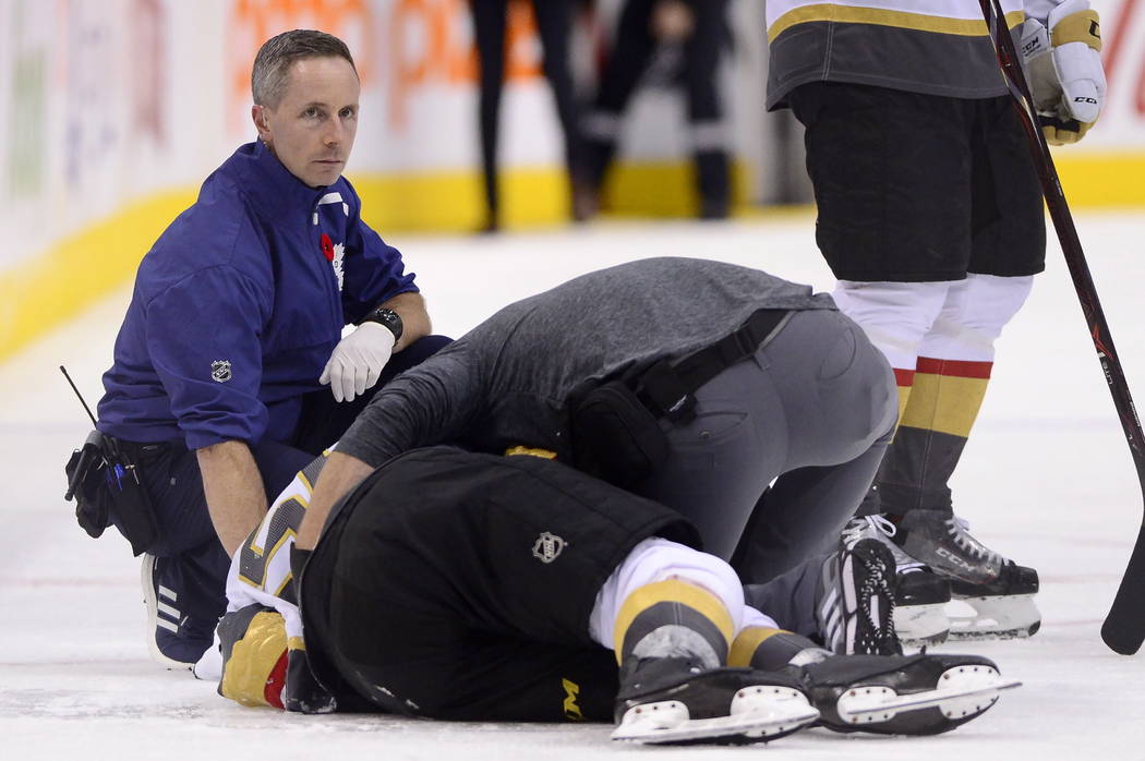 A trainer attends to Vegas Golden Knights center Erik Haula (56), who had taken a hit along the boards during the third period of an NHL hockey game against the Toronto Maple Leafs on Tuesday, Nov ...