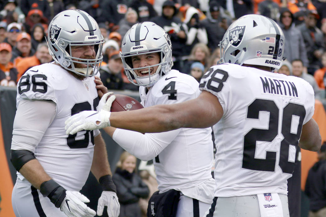 Oakland Raiders quarterback Derek Carr (4) celebrates his touchdown pass to tight end Lee Smith (86) with running back Doug Martin (28) during the first half of an NFL game against the Cincinnati ...