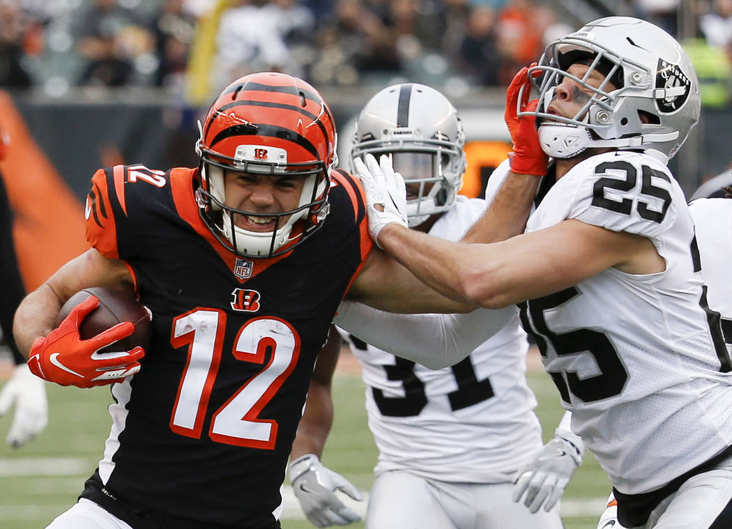 Cincinnati Bengals wide receiver Alex Erickson (12) runs the ball against Oakland Raiders free safety Erik Harris (25) in the second half of an NFL football game, Sunday, Dec. 16, 2018, in Cincinn ...