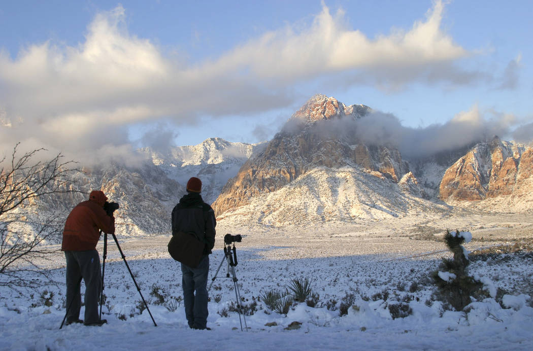 Photographers gather at the Red Rock Overlook on state Route 159 to capture images of the snow-covered mountains of Red Rock Canyon National Conservation Area in the early morning on Dec. 19, 2008 ...