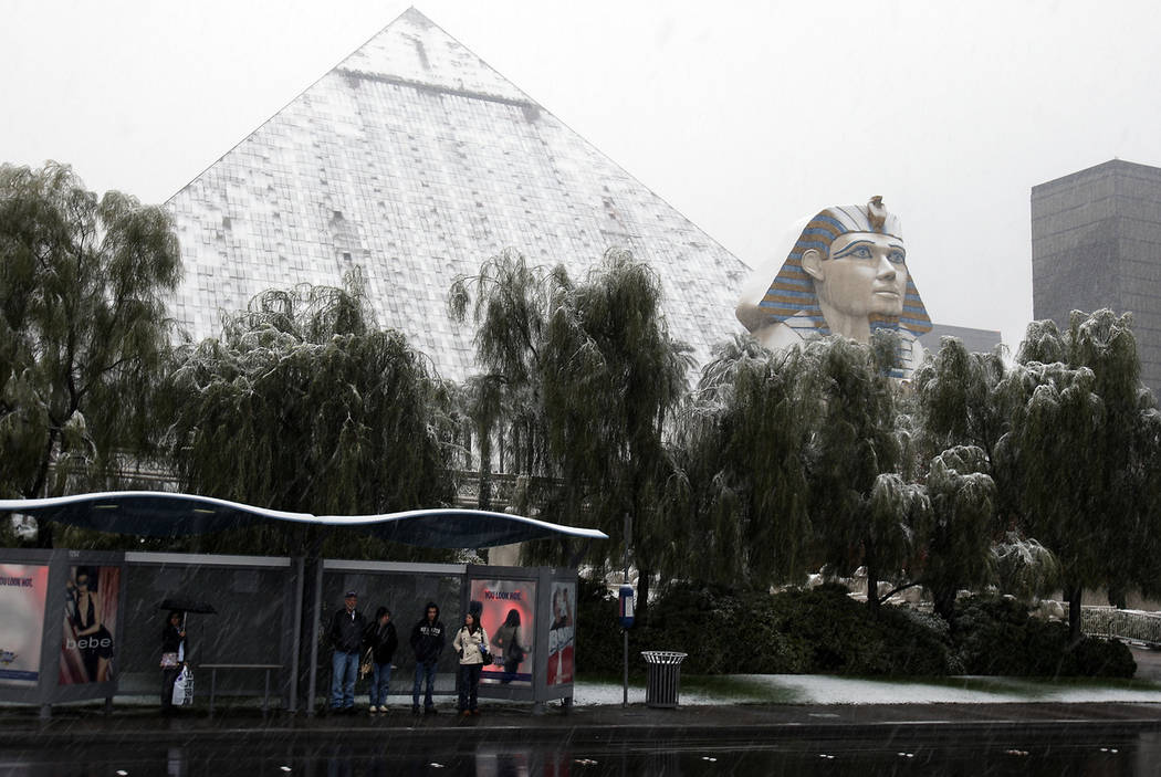 People wait for a bus as falling snow covers the Luxor on the Las Vegas Strip, Dec. 17, 2008. (John Gurzinski/Las Vegas Review-Journal)