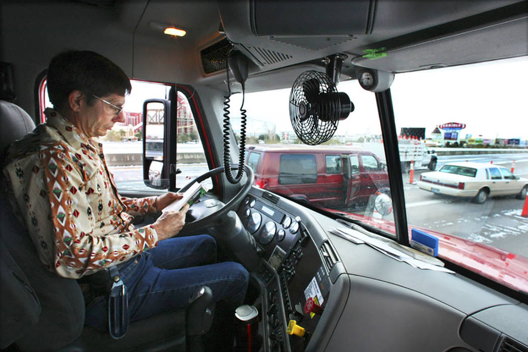 Tractor-trailer truck driver Gary Mott catches up on his reading on Interstate 15 in Primm on Dec. 18, 2008, after the interstate was closed due to the winter storm that passed through the area. ( ...
