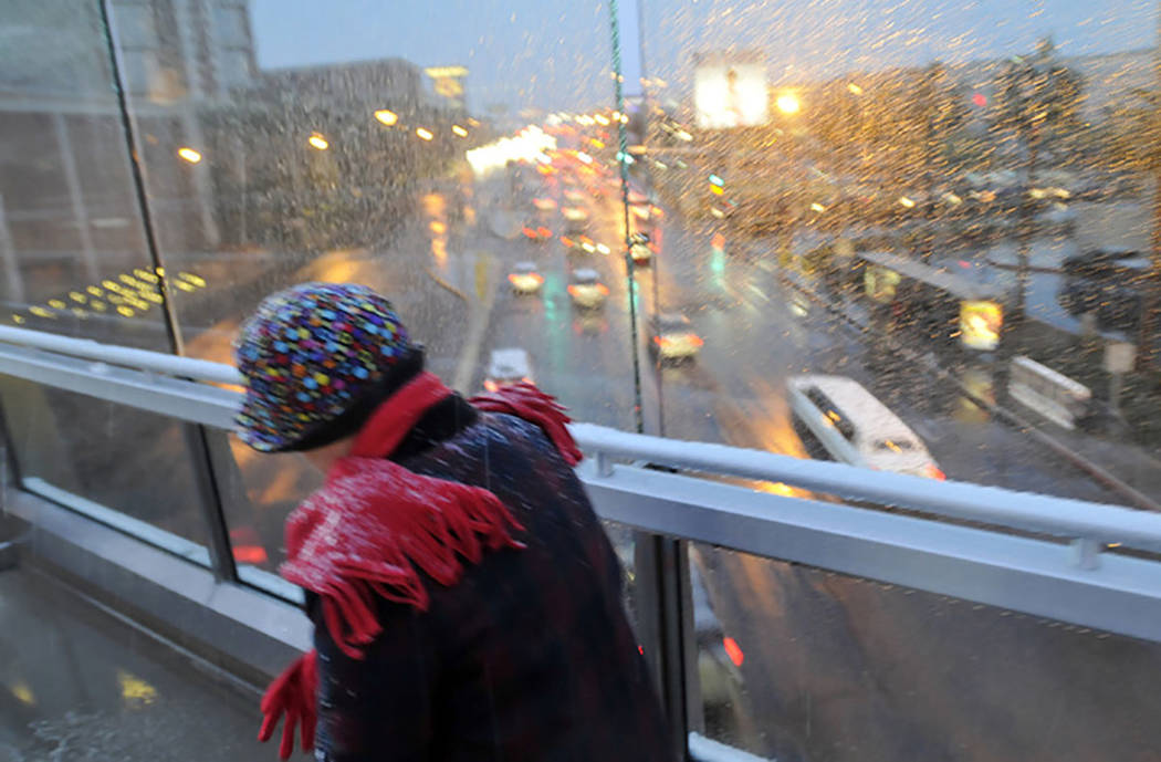 A woman bundled up braves the freezing rain and snow as she crosses one of the pedestrian bridges along the Las Vegas Strip on Dec. 17, 2008. (Las Vegas Review-Journal)