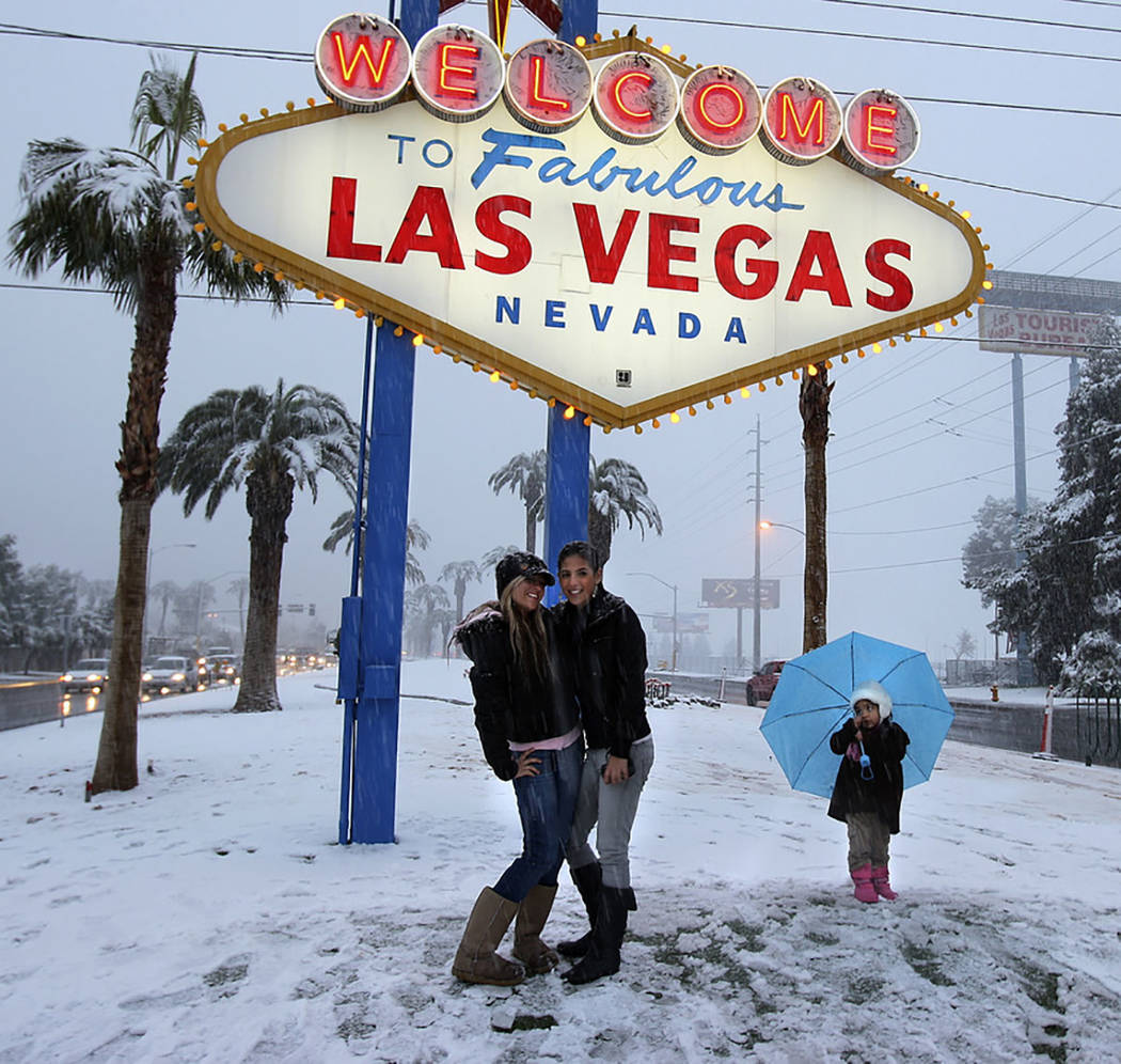 Visitors have their picture taken at the welcome sign during a snowstorm on the Las Vegas Strip on Dec. 17, 2008. (Las Vegas Review-Journal)