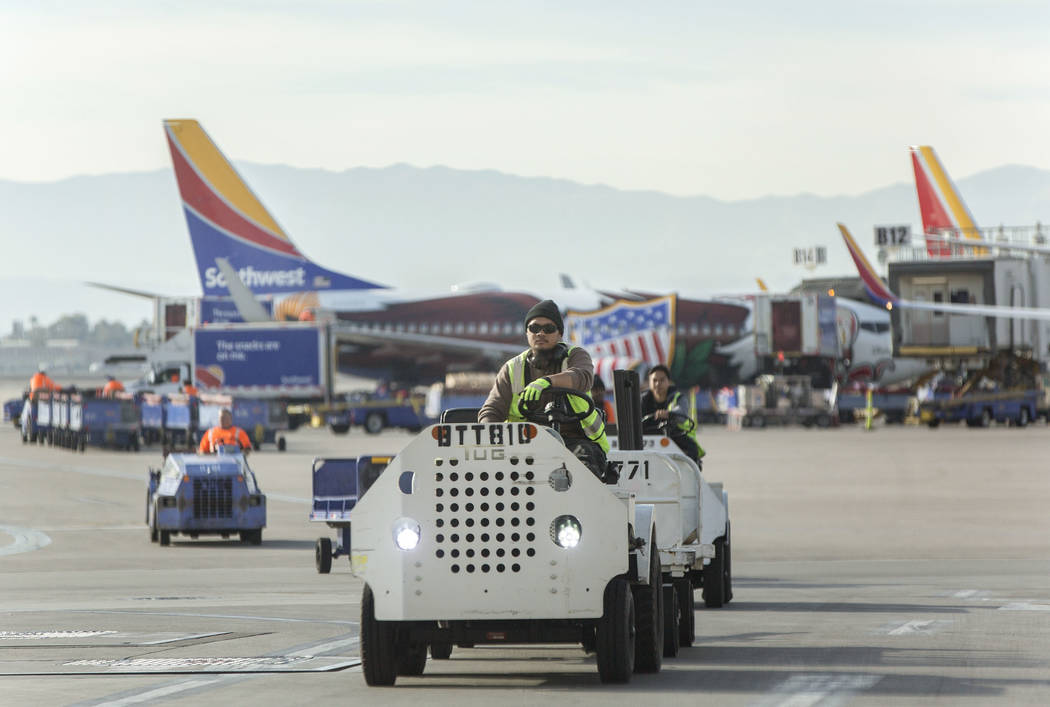 Southwest workers transfer baggage on the airport tarmac at McCarran International Airport on Tuesday, Dec. 18, 2018, in Las Vegas. Benjamin Hager Las Vegas Review-Journal