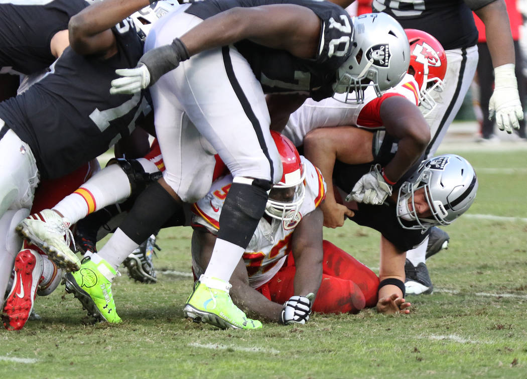 Oakland Raiders quarterback Derek Carr (4) is sacked by Kansas City Chiefs outside linebacker Justin Houston (50) and defensive end Chris Jones (95) during the second half of an NFL game in Oaklan ...