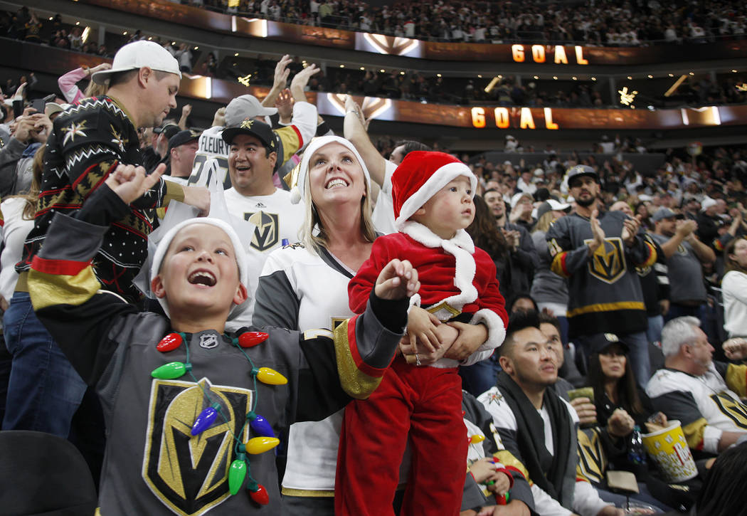 The Tra family, from left, Tyson Tra, 7, Gabrielle Tra and Tatum Tra, 2, cheer after the Vegas Golden Knights scored against the Los Angeles Kings in the second period at T-Mobile Arena in Las Veg ...