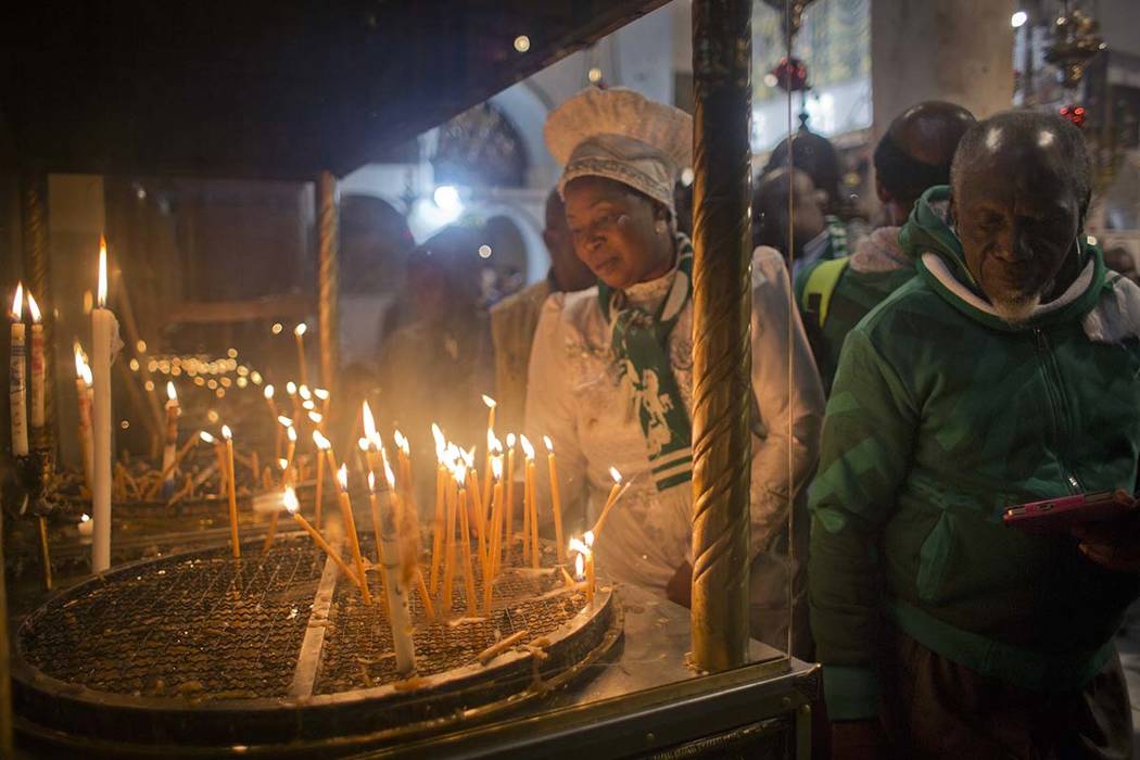 Christian worshippers light candles at the Church of the Nativity, traditionally recognized by Christians to be the birthplace of Jesus Christ, in the West Bank city of Bethlehem, Sunday, Dec. 23, ...