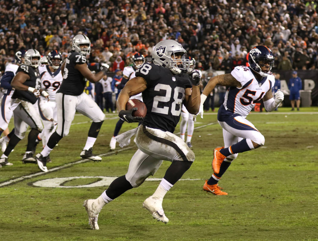 Oakland Raiders running back Doug Martin (28) runs with the football as Denver Broncos inside linebacker Brandon Marshall (54) tries to catch up during the first half of an NFL game in Oakland, Ca ...