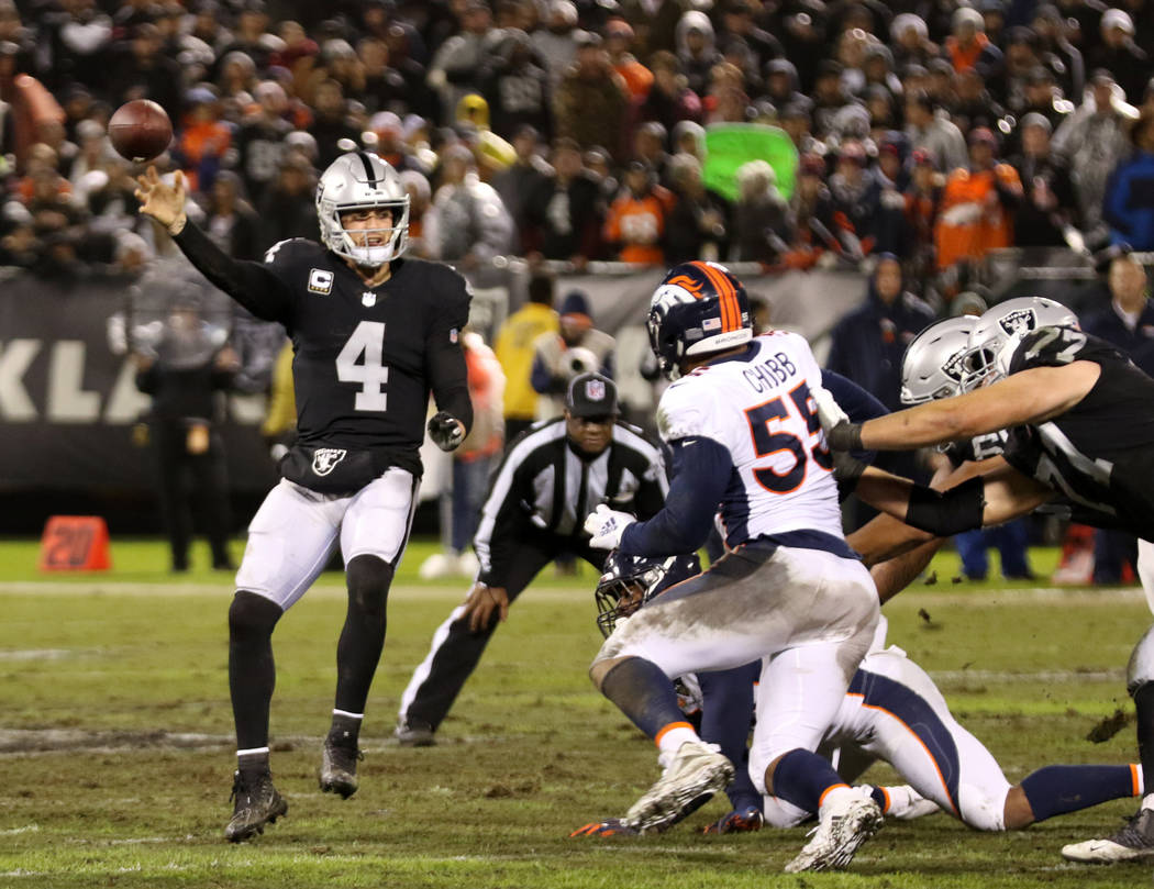 Oakland Raiders quarterback Derek Carr (4) throws thr football as Denver Broncos outside linebacker Bradley Chubb (55) closes in during the first half of an NFL game in Oakland, Calif., Monday, De ...
