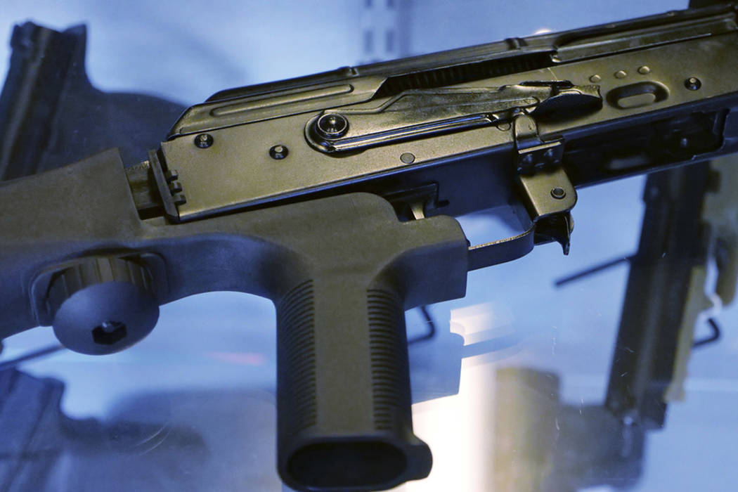 A device called a "bump stock" is attached to a semi-automatic rifle at the Gun Vault store and shooting range in South Jordan, Utah on Oct. 4, 2017. (AP Photo/Rick Bowmer)