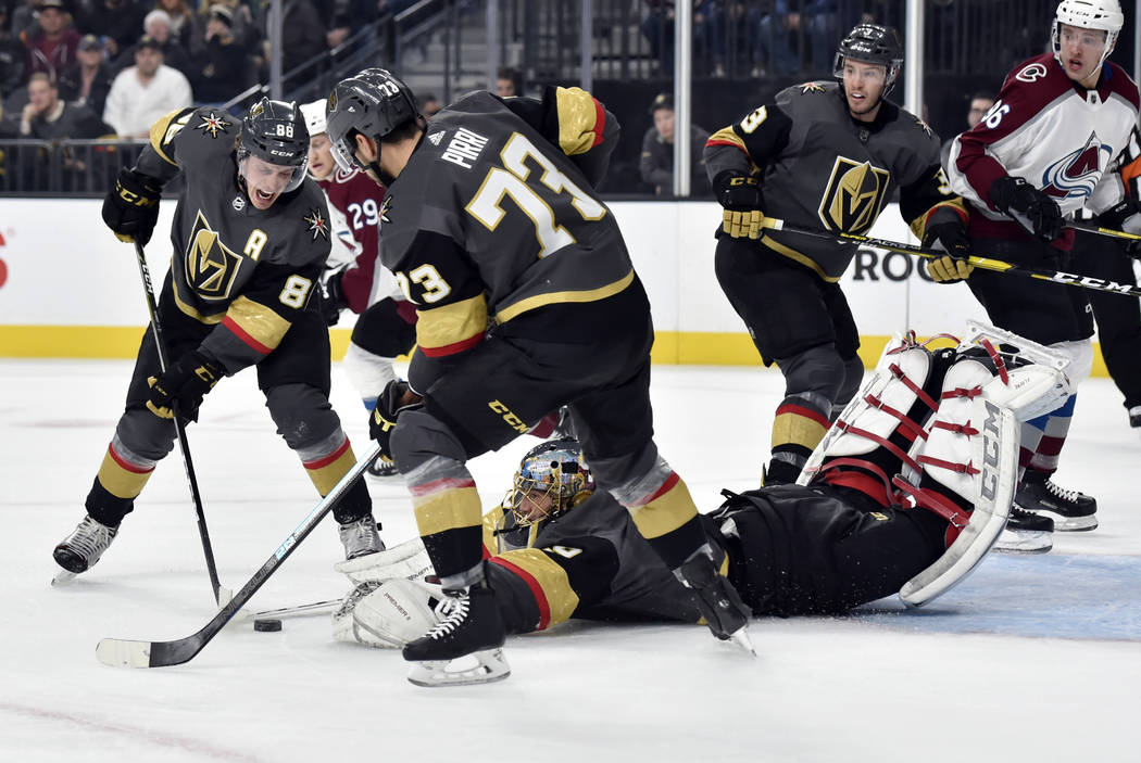 Vegas Golden Knights goaltender Marc-Andre Fleury (29) dives for the puck with Nate Schmidt (88) and Brandon Pirri (73) defending against the Colorado Avalanche during the first period of an NHL h ...