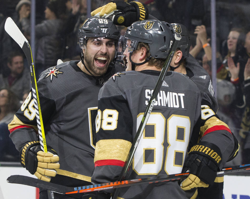 Golden Knights right wing Alex Tuch (89) celebrates with teammate Nate Schmidt (88) after assisting on a first period goal during Vegas' home matchup with the Colorado Avalanche on Thursday, Dec. ...