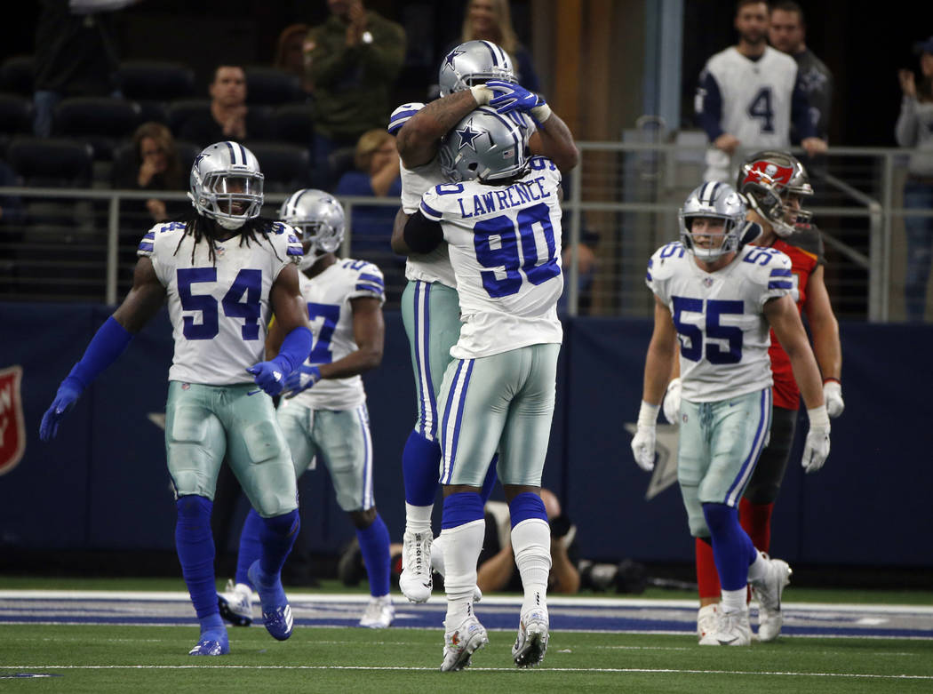 Dallas Cowboys' DeMarcus Lawrence (90) and Antwaun Woods, being lifted celebrate a stop against the Tampa Bay Buccaneers as Jaylon Smith (54) and Leighton Vander Esch (55) look on in the second ha ...
