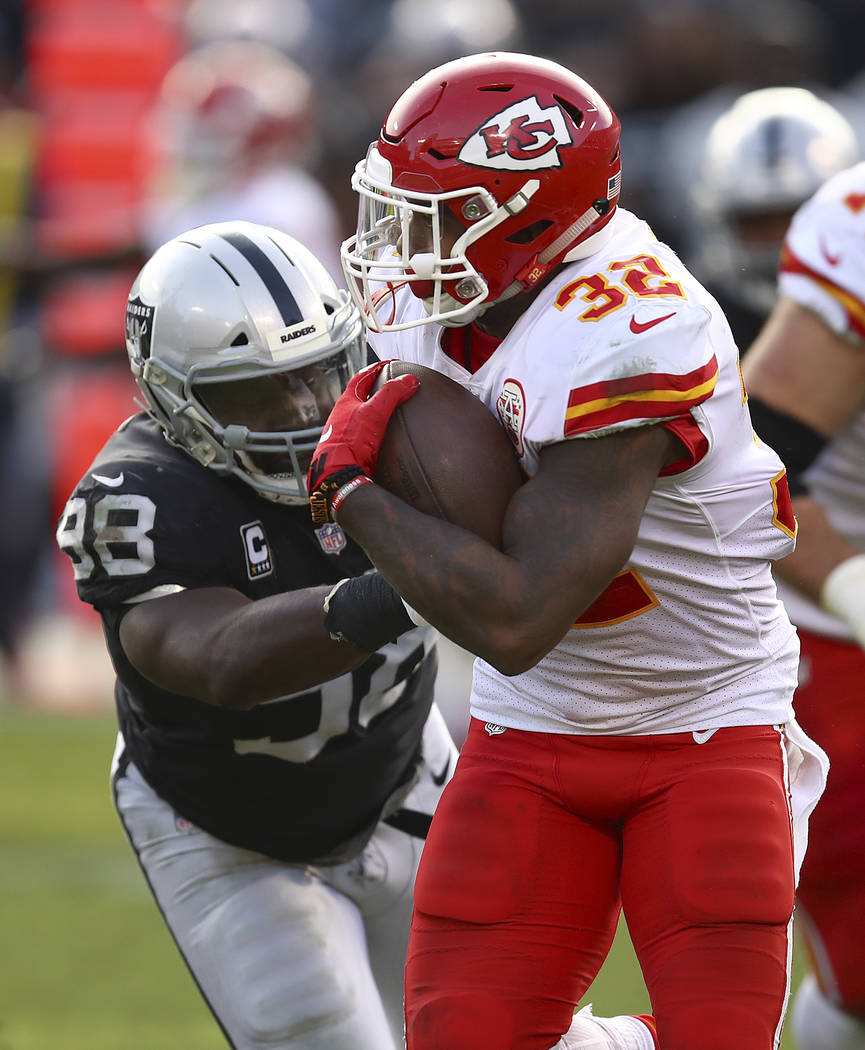 Kansas City Chiefs running back Spencer Ware (32) runs against Oakland Raiders defensive tackle Frostee Rucker (98) during an NFL football game in Oakland, Calif., Sunday, Dec. 2, 2018. (AP Photo/ ...