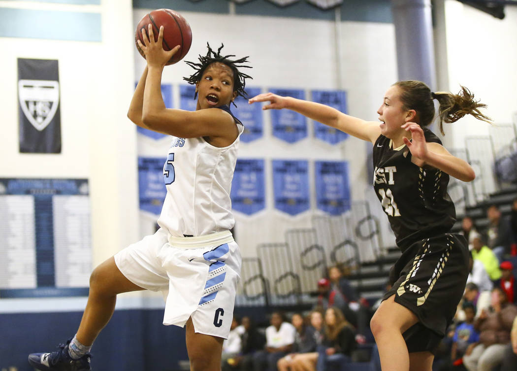 CentennialÕs Daejah Phillips (15) looks to pass under pressure from WestÕs Ella Estabrook (21) during a basketball game at Centennial High School in Las Vegas on Saturday, Dec. 29, 2018. ...