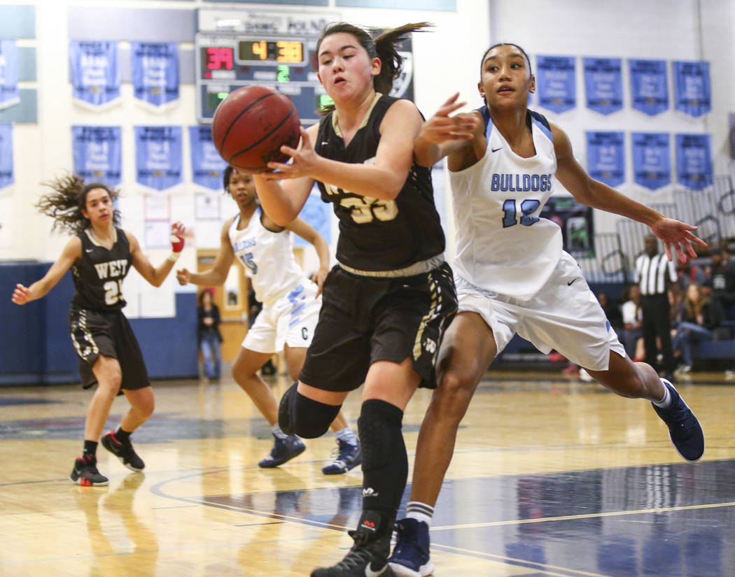 Centennial’s Aishah Brown (12) tries to block a pass to West’s Piper Takenaka (33) during a basketball game at Centennial High School in Las Vegas on Saturday, Dec. 29, 2018. Chase S ...